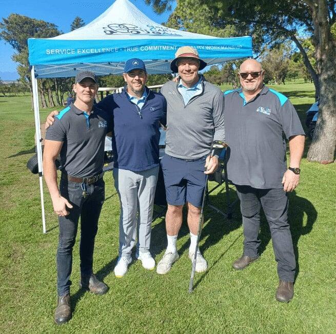 Golf Carts & All team with Schalk Burger at a golf day, standing in front of branded gazebo with displayed golf carts and accessories