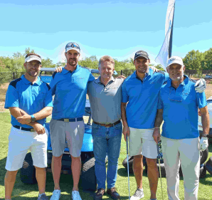 Golf cart and all managing director taking a photo with one of the teams during a golf day.